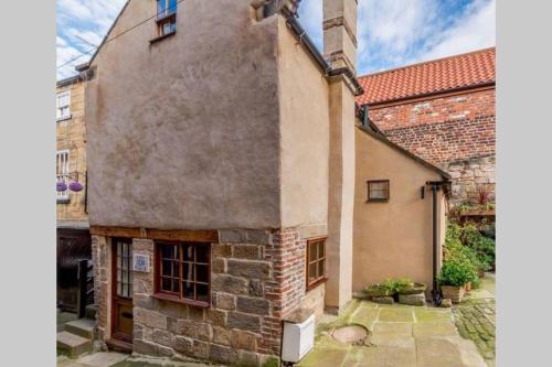 an old stone house with a brick building at The Cow House - In the heart of Whitby in Whitby