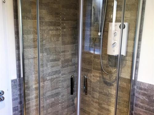 a shower in a bathroom with a glass door at Hillview in Ballater