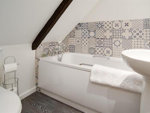 a bathroom with a bath tub and a sink at Chatton Cottage in Chatton