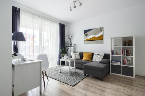 a living room with a couch and a table at M&R Apartament Airport&Business Premium Komputerowa - underground garage - free WiFi - Netflix - self check-in - 5 min from Chopin Airport in Warsaw
