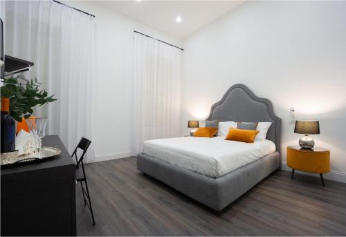 1 dormitorio con 1 cama con almohadas de color naranja en Suite Rodinò 24, en Nápoles