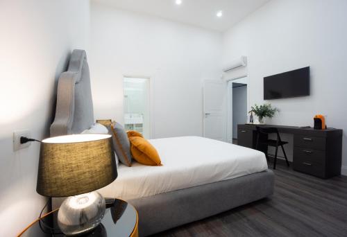 1 dormitorio con 1 cama con lámpara y escritorio en Suite Rodinò 24, en Nápoles
