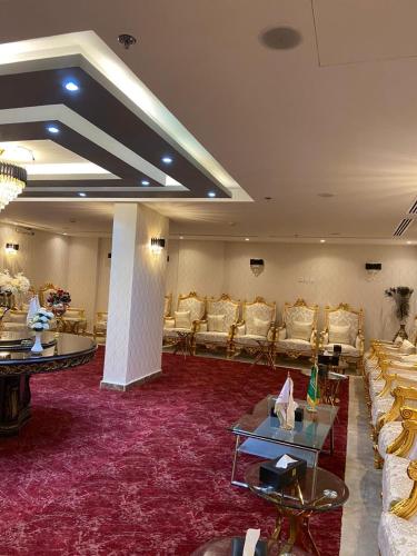 a large room with couches and tables and chairs at Jazan Inn Hotel in Jazan