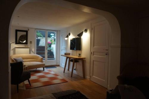 ein Wohnzimmer mit einem Sofa und einem Tisch in der Unterkunft Le calme à 2 pas de Paris in Levallois-Perret