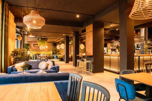 a living room with a blue couch and chairs at Hotel Marktstad in Schagen