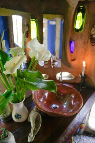 a bathroom with a sink and a vase with flowers at Lo De Ro in Barra de Valizas