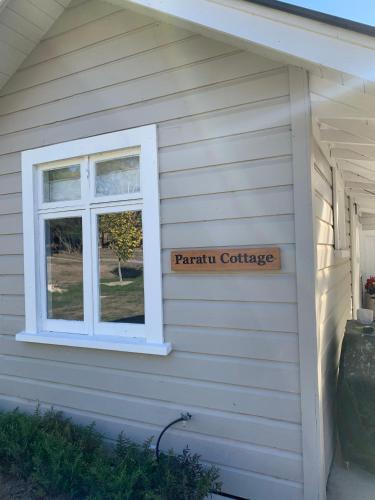 a sign on the side of a house with a window at Paratu Farm Cottage in a quiet rural setting. in  Waipukurau