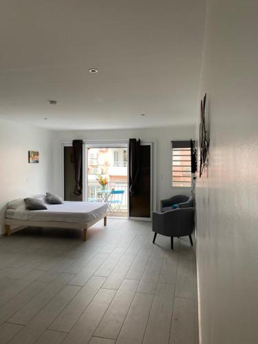 a bedroom with a bed and a chair in a room at Résidence VWAL O VAN 2, studio plage à proximité in Sainte-Anne