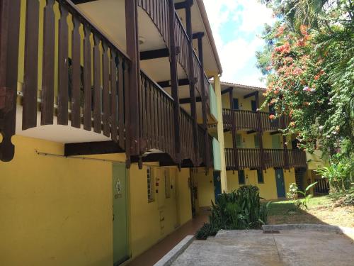 a yellow and green building with a staircase at Studios Haut de Caritan in Sainte-Anne