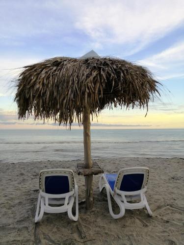 two chairs and an umbrella on the beach at Playa Blanca in Playa Blanca
