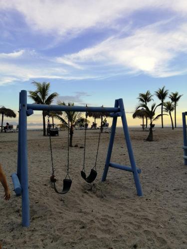 a swing set on a beach with palm trees at Playa Blanca in Playa Blanca