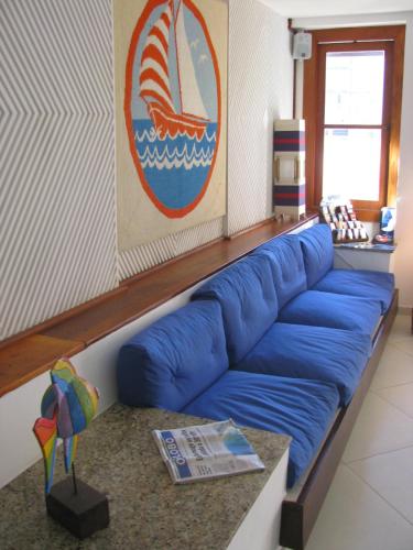 a blue couch in a living room with a table at Hotel La Brise in Cabo Frio