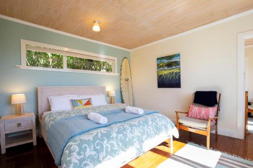 ein Schlafzimmer mit einem Bett und einem Stuhl in der Unterkunft Seascapes in Punakaiki