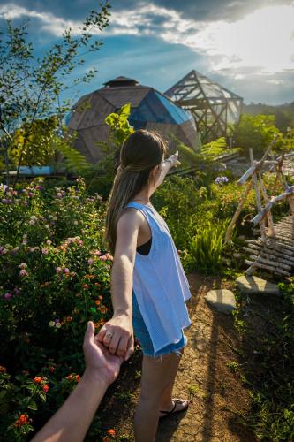 a woman holding a persons hand in a garden at Nacimiento Glamping in San Agustín