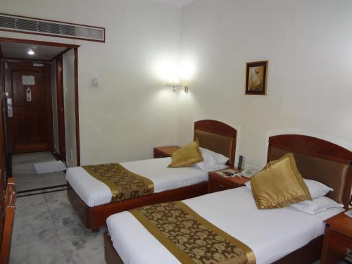 a hotel room with two beds and a telephone at Daspalla Executive Court in Visakhapatnam