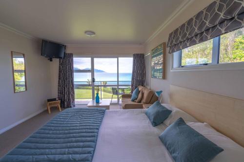 a bedroom with a large bed with a large window at Bendamere House Bed & Breakfast in Kaikoura