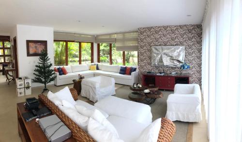 uma sala de estar com sofás brancos e cadeiras em Costa do Sauipe - Casa de Luxo Temporada - Bahia - Condominio Quintas de Sauipe Grande Laguna - Ate 7 Adultos na Costa do Sauípe