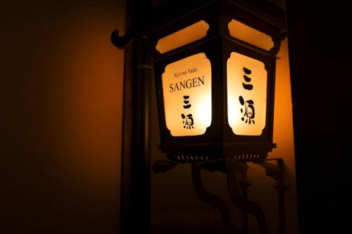 a lantern with two signs on the side of it at Kyo no Yado Sangen Ninenzaka in Kyoto