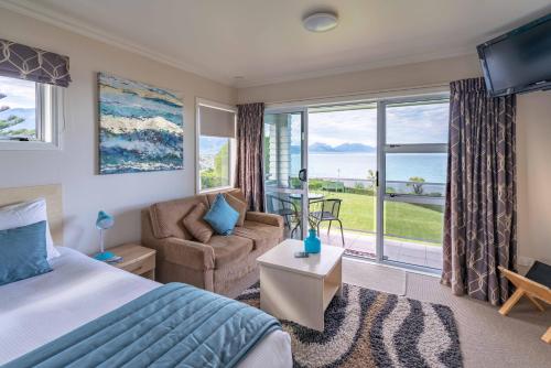 a bedroom with a bed and a couch and a window at Bendamere House Bed & Breakfast in Kaikoura
