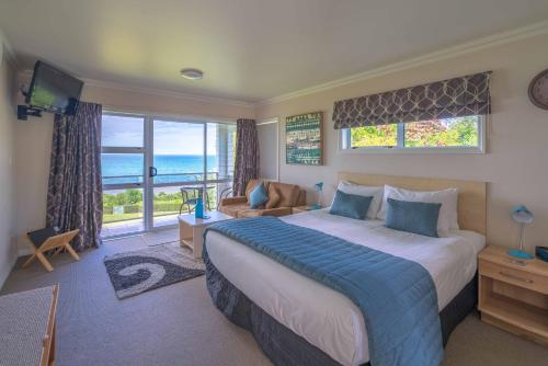 a bedroom with a large bed and a view of the ocean at Bendamere House Bed & Breakfast in Kaikoura