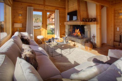 a living room with a couch and a fireplace at Chalet Alpachic - OVO Network in La Clusaz
