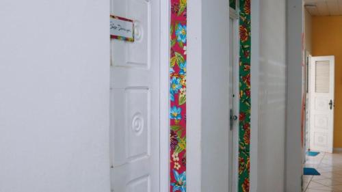 pasillo con puerta blanca y papel pintado colorido en Z-18 Hostel, en Barreirinhas