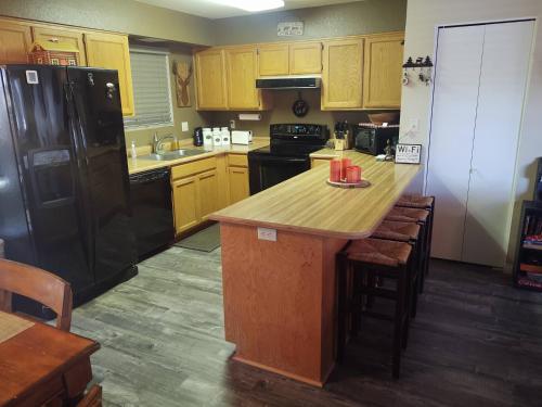 a kitchen with a black refrigerator and a wooden counter top at 2BR Gated Escape With A Pool And Walk to Dining and Trails in Pinetop-Lakeside