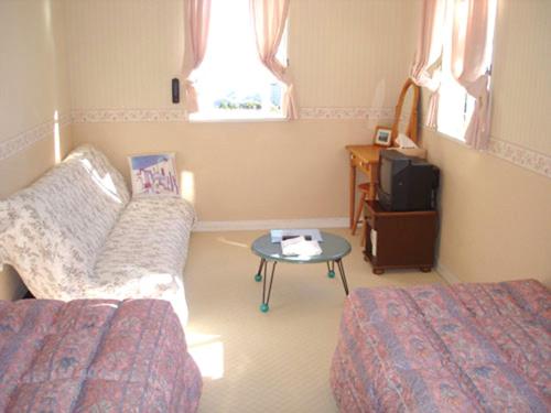 a room with a bed and a table and a couch at Kamo-gun - Hotel / Vacation STAY 50723 in Okawa