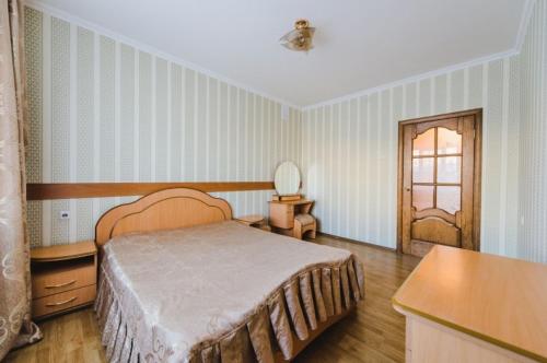 チタにあるDekabrist Apartment on Lenina 17のベッドルーム1室(ベッド1台、テーブル、ドア付)