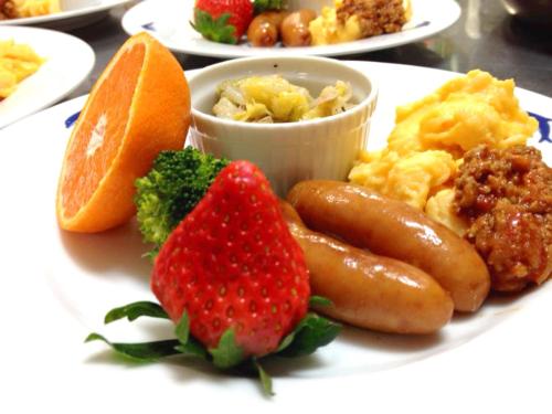 un piatto di alimenti con salsiccia e frutta su un tavolo di Kamo-gun - Hotel / Vacation STAY 41224 a Okawa
