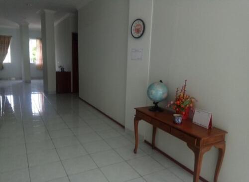a room with a table and a clock on a wall at Rumah Kita in Padang