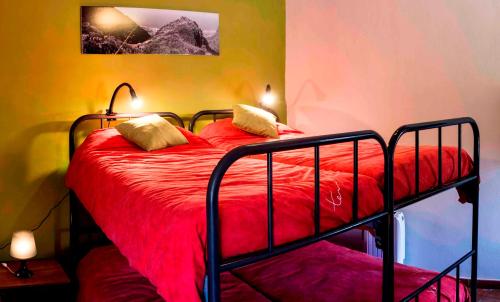 a bedroom with a bed with a red comforter at Albergue de Bolico in Buenavista del Norte