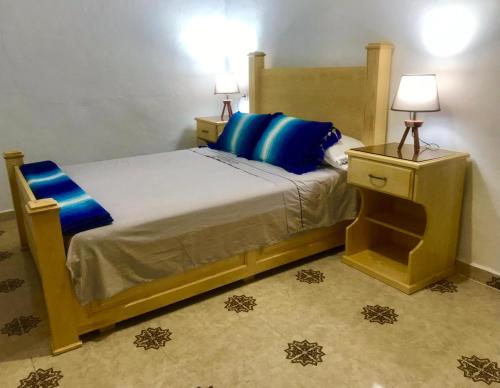 a bedroom with a bed with blue pillows at Dar Sidi Mfedal in Chefchaouene