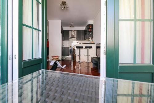 a hallway with a green door and a kitchen at Parede Flats in Parede