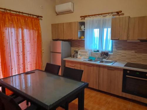 a kitchen with a table and a kitchen with a refrigerator at Stone Villa at Alyki Beach in Alikí