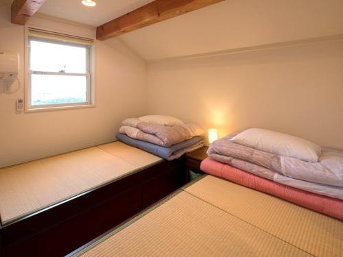 Duas camas num pequeno quarto com uma janela em Kamo-gun - Hotel / Vacation STAY 50721 em Okawa