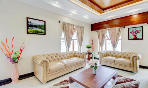 a living room with two couches and a table at Treebo The Meridian in Chikmagalūr