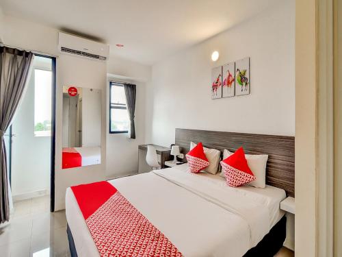 a bedroom with a bed with red and white pillows at Collection O 92440 Urban Town Apartment Karawang in Telukjambe
