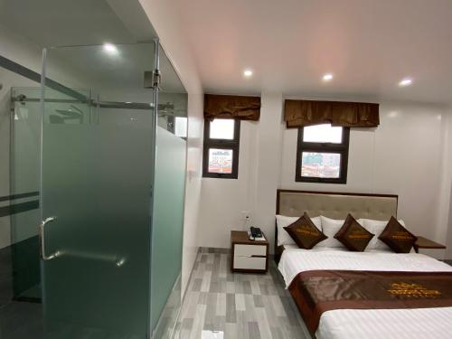 1 dormitorio con 1 cama y ducha acristalada en Trường Sinh Hotel, en Hai Phong
