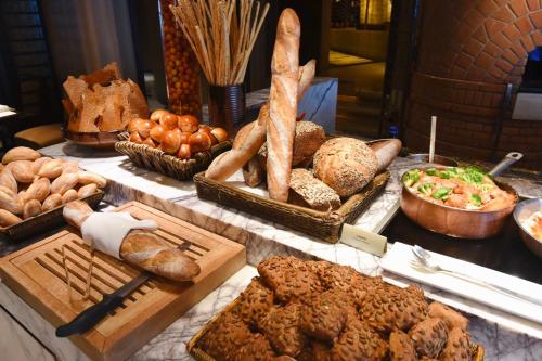 a table with various types of bread and pastries at Grand Hyatt Shanghai in Shanghai