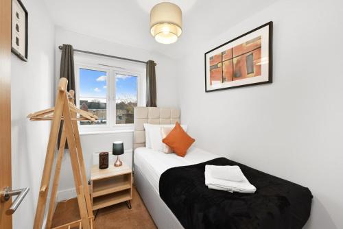 a small bedroom with a bed and a ladder at London Heathrow Living Holywell Serviced Houses - 3 and 4 bedrooms By Ferndale in Stanwell