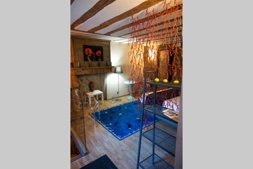 - un salon avec un tapis bleu et une table dans l'établissement Caveau Contemporain KV'O37, à Arbois