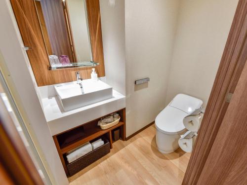 
a bathroom with a toilet, sink, and mirror at Asakusa Tobu Hotel in Tokyo
