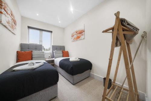 a bedroom with two beds and a ladder in it at London Heathrow Living Holywell Serviced Houses - 3 and 4 bedrooms By Ferndale in Stanwell