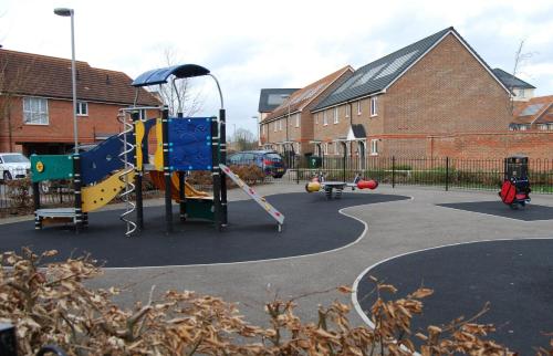 a playground with a slide and a swing set at London Heathrow Living Holywell Serviced Houses - 3 and 4 bedrooms By Ferndale in Stanwell