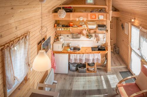 a kitchen in a tiny house with wooden walls at Tiny House Lavender in Podtureň