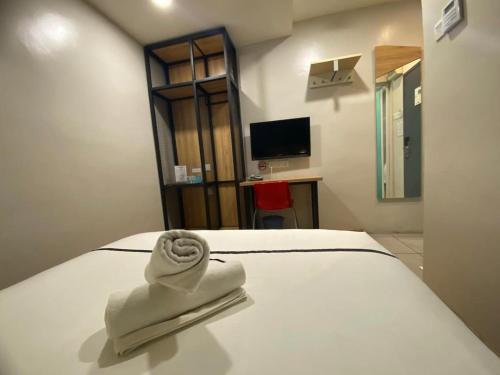 una habitación de hotel con una toalla blanca en una cama en Smile Hotel Selayang Point, en Cuevas de Batu