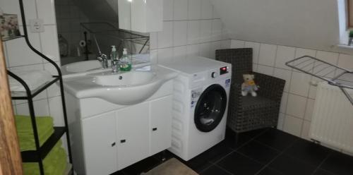 a bathroom with a washing machine and a washer at FEWO Elbe Weser in Hipstedt