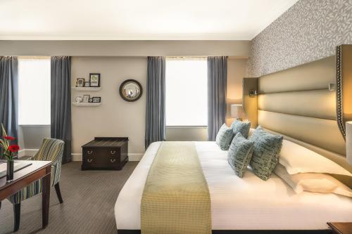 a hotel room with a large bed and a desk at The Bailey's Hotel London Kensington in London