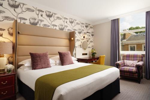 ロンドンにあるThe Bailey's Hotel London Kensingtonの大きなベッドと窓が備わるホテルルームです。